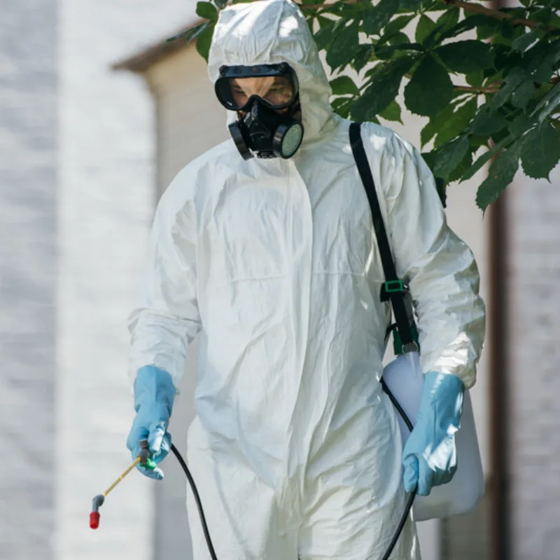 Technicien Dushenne en combinaison de protection pendant un traitement contre les nuisibles